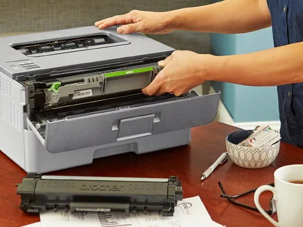 Woman installing new toner cartridge in printer