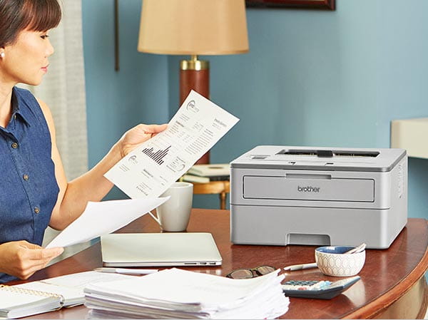 Woman reviewing printed documents in home office
