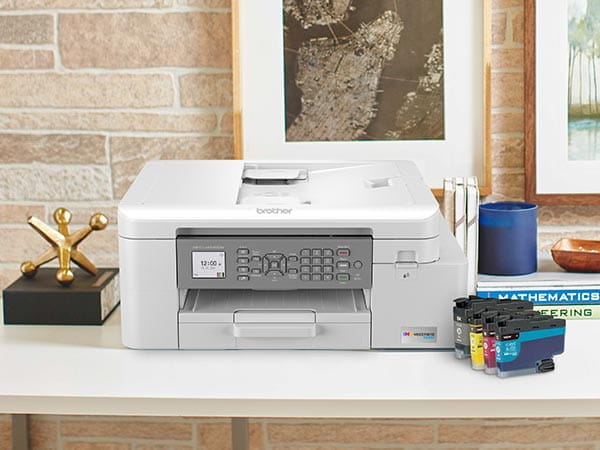Printer on home office desk with ink cartridges