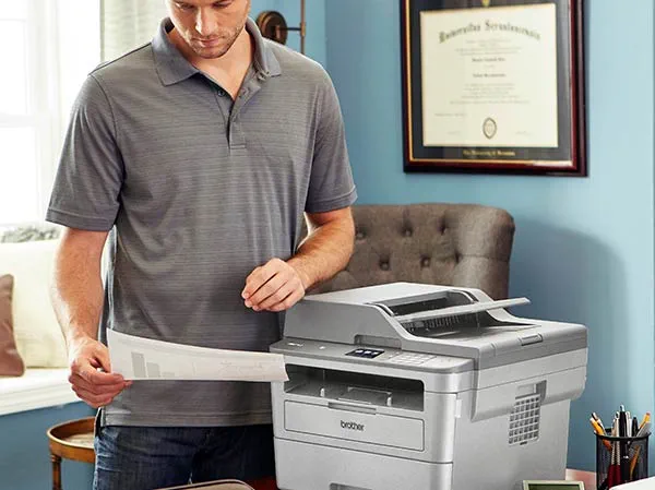 Man reviewing printed documents in home office